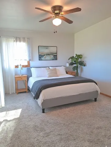 a spacious bedroom with a bed and a chandelier
