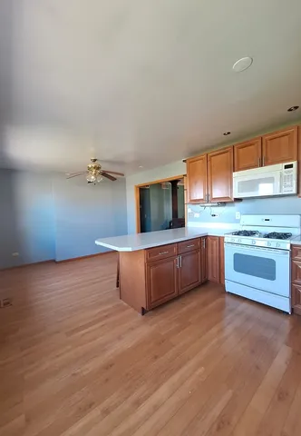 a kitchen with stainless steel appliances kitchen island wooden cabinets and a couch