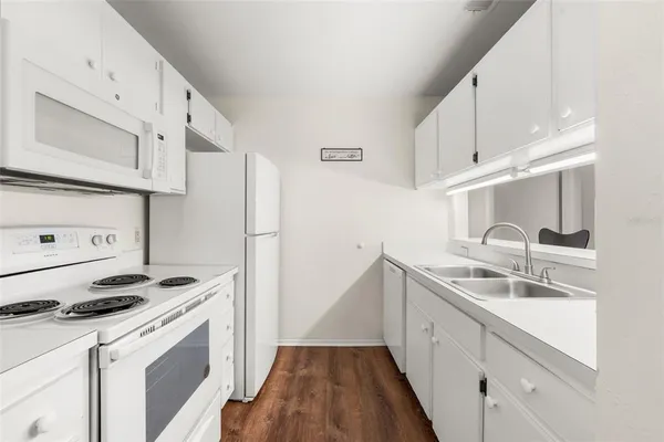 a kitchen with granite countertop a sink stove and refrigerator