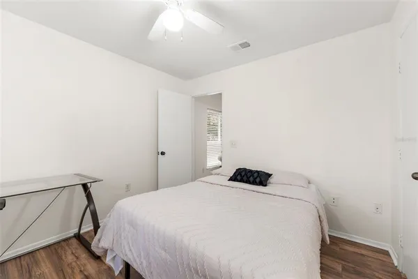 a bedroom with a bed and wooden floor