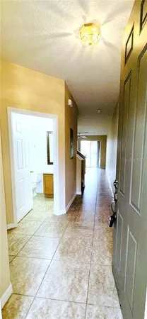 a view of a hallway with wooden floor and a bathroom