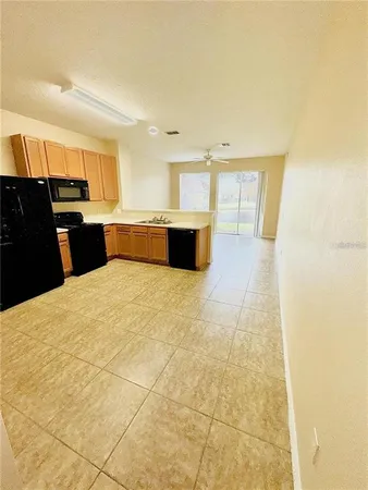 a large kitchen with a stove a sink and a refrigerator