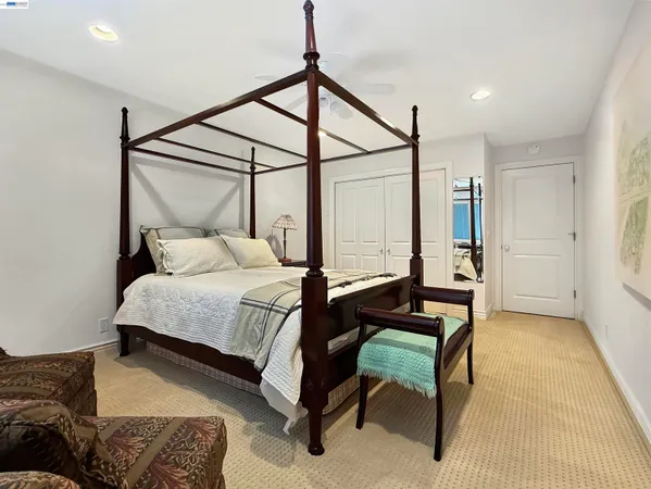 a bedroom with a bed window and table chair