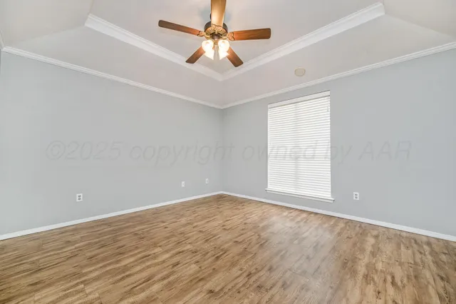 an empty room with a window and a fan