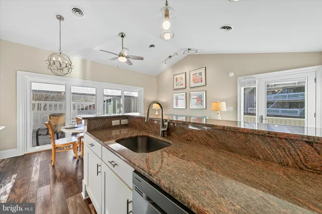 a kitchen with stainless steel appliances granite countertop a sink a stove and a wooden cabinets