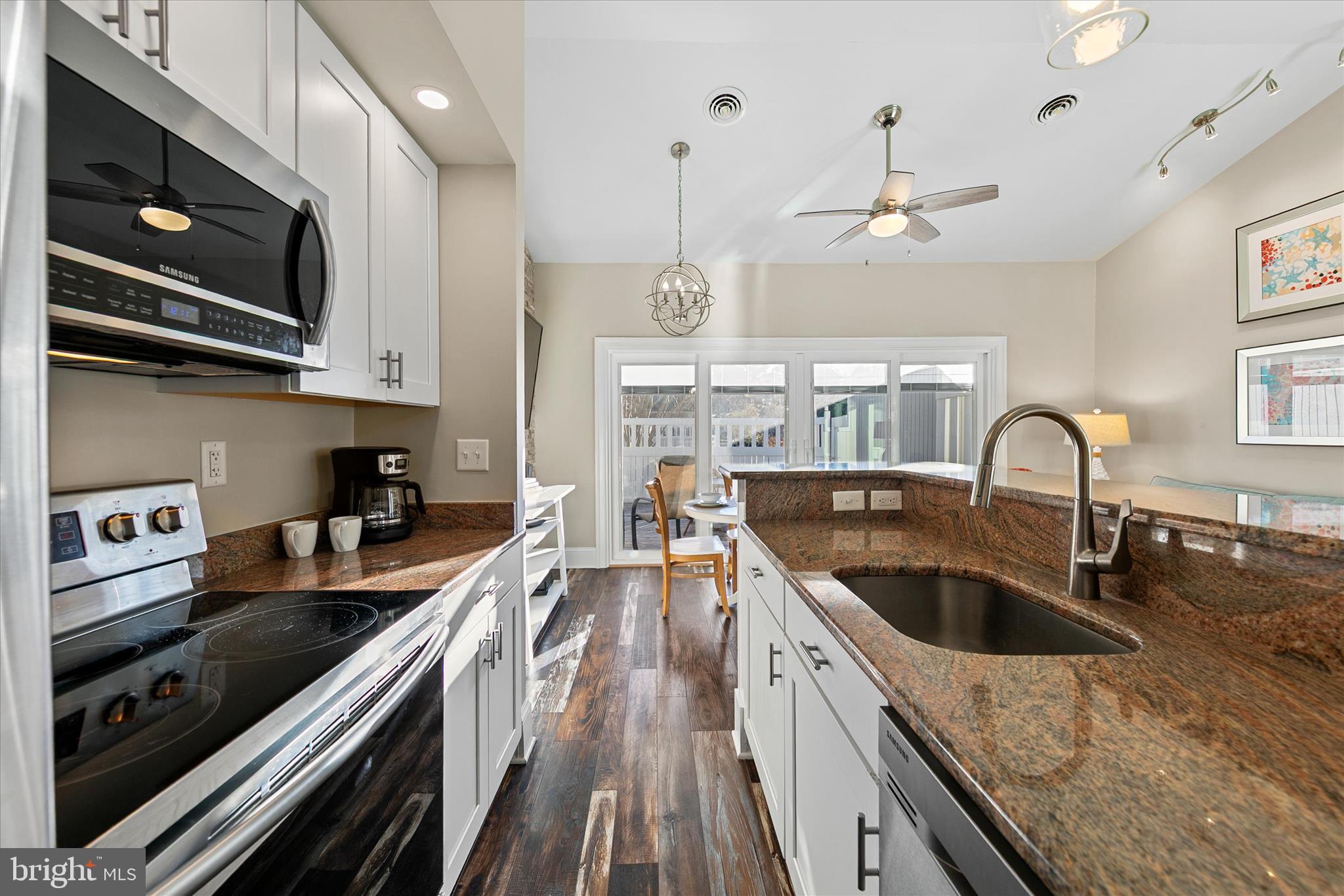 39655 Tie Breaker Court, Unit 4801 Bethany Beach, DE 19930 - Photo 21 of 58 a kitchen with stainless steel appliances granite countertop a sink a stove and a wooden floors