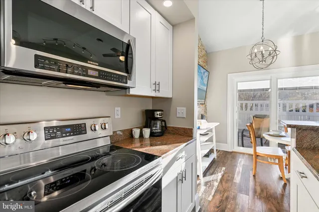 a bedroom with a large bed a chandelier and dresser