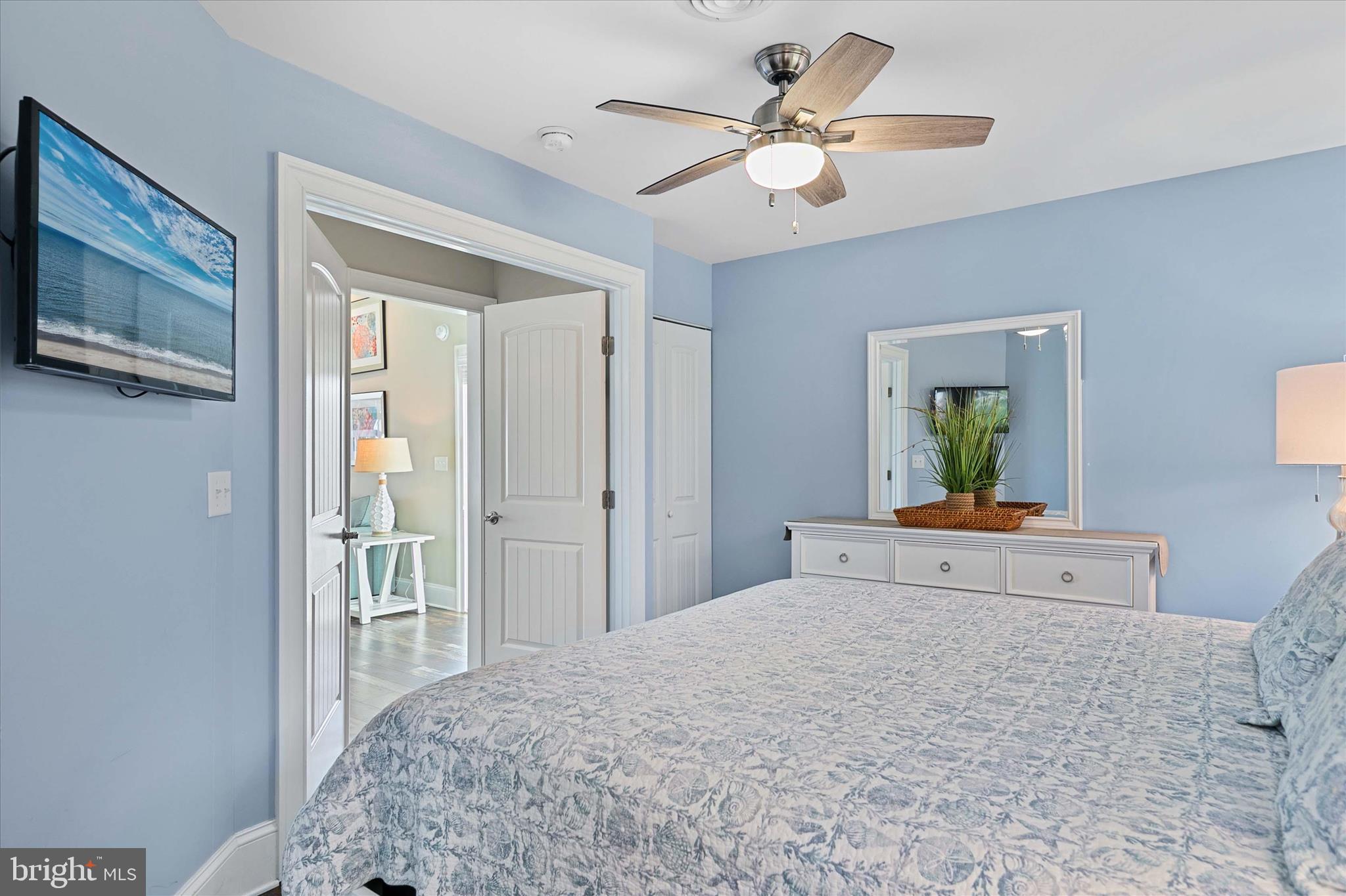 39655 Tie Breaker Court, Unit 4801 Bethany Beach, DE 19930 - Photo 25 of 58 a bedroom with a large bed a chandelier and dresser