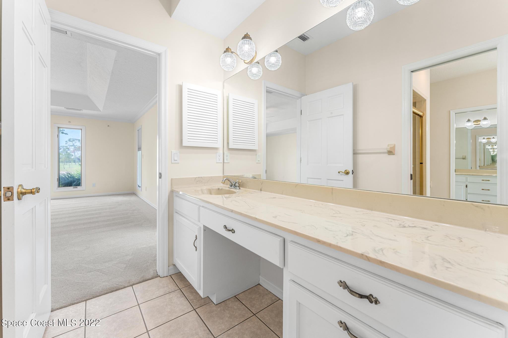 750 Kerry Downs Circle Melbourne, FL 32940 - Photo 13 of 34 a spacious bathroom with a granite countertop sink a mirror and a