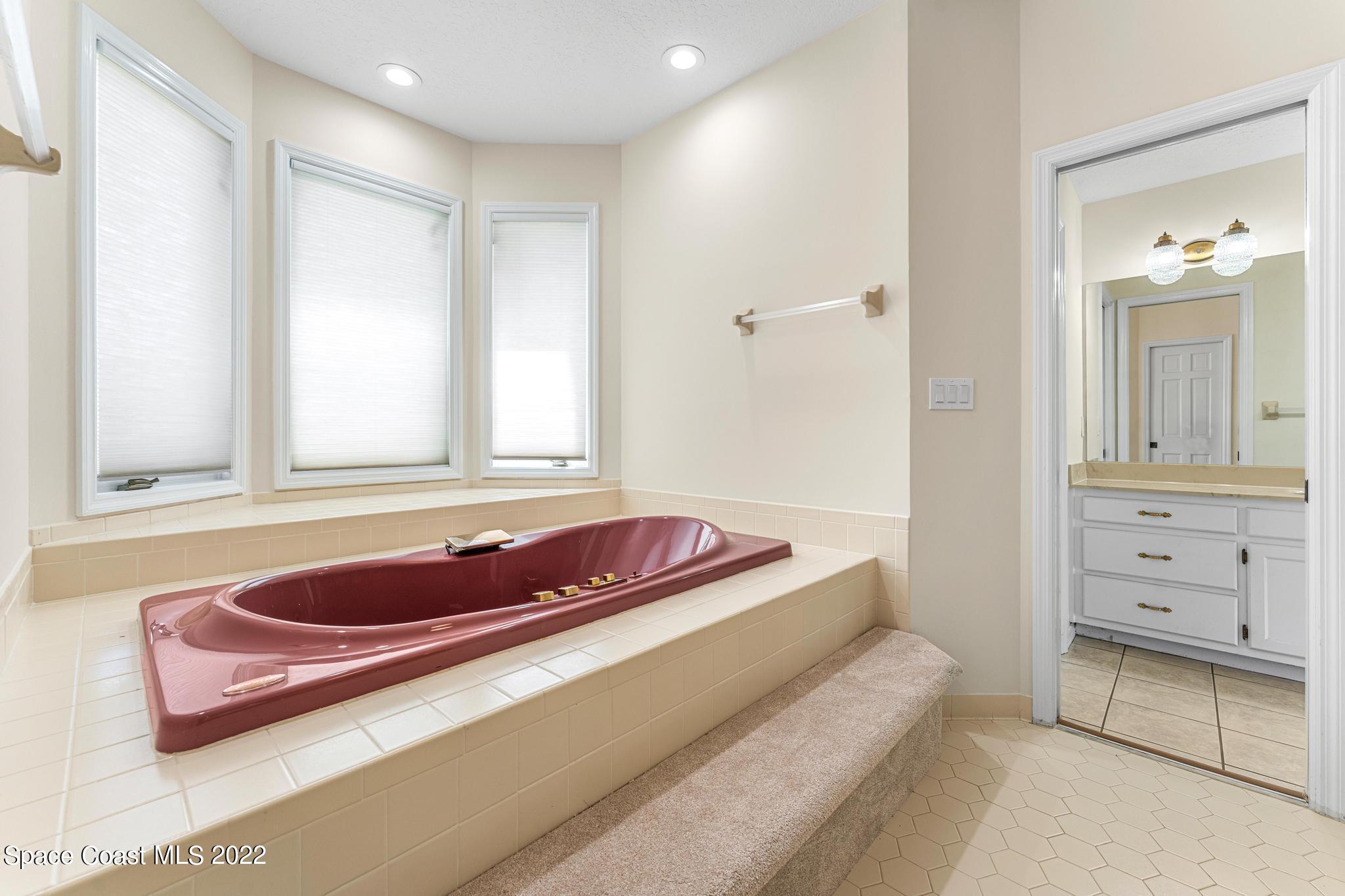 750 Kerry Downs Circle Melbourne, FL 32940 - Photo 14 of 34 a bathroom with a tub sink and mirror