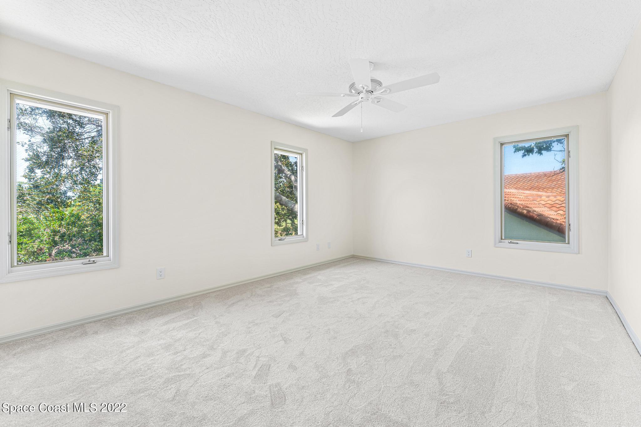 750 Kerry Downs Circle Melbourne, FL 32940 - Photo 16 of 34 an empty room with windows and fan