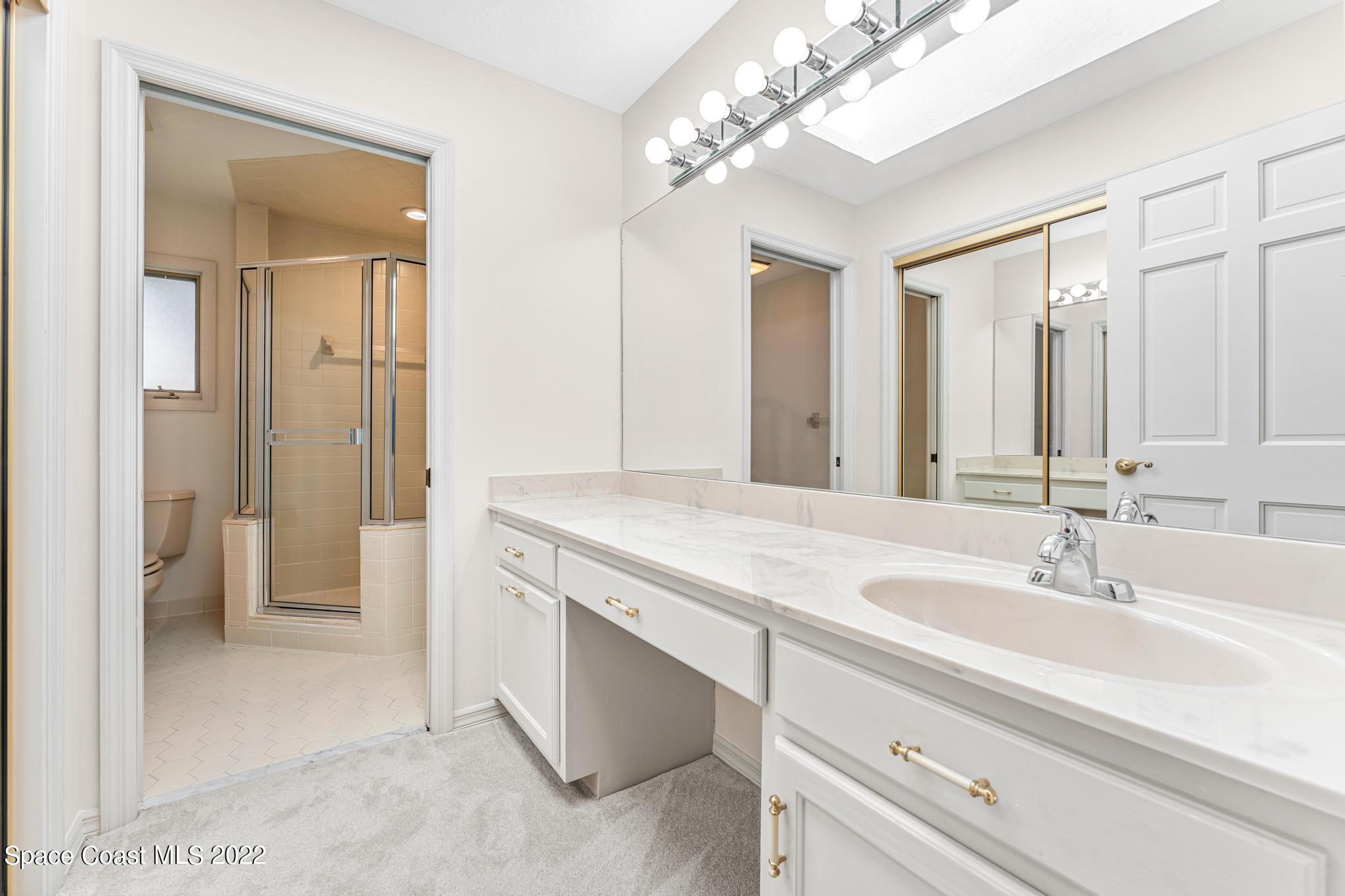 750 Kerry Downs Circle Melbourne, FL 32940 - Photo 17 of 34 a spacious bathroom with a granite countertop sink a mirror and a shower