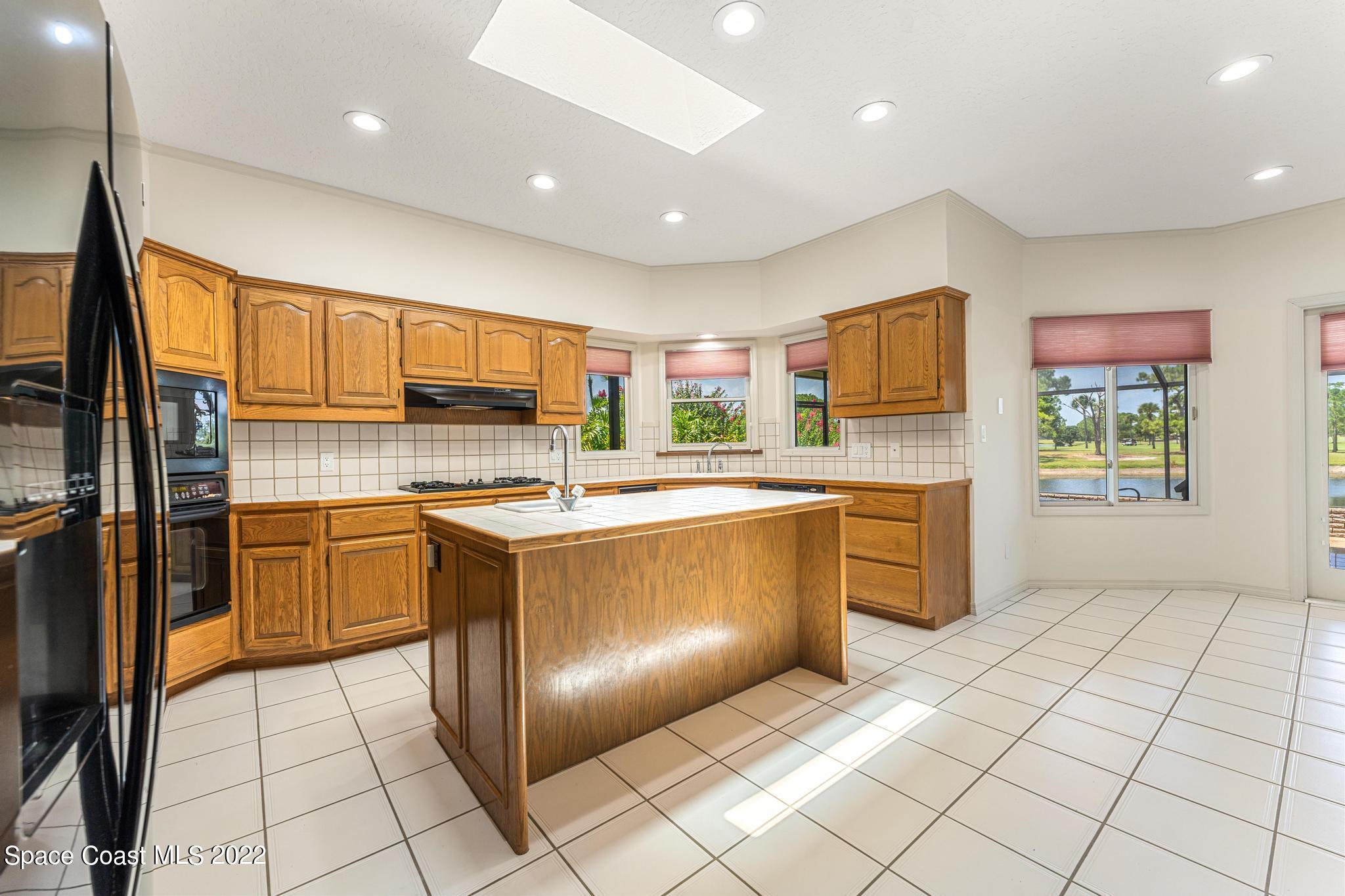 750 Kerry Downs Circle Melbourne, FL 32940 - Photo 9 of 34 a kitchen with stainless steel appliances granite countertop a refrigerator and a stove top oven