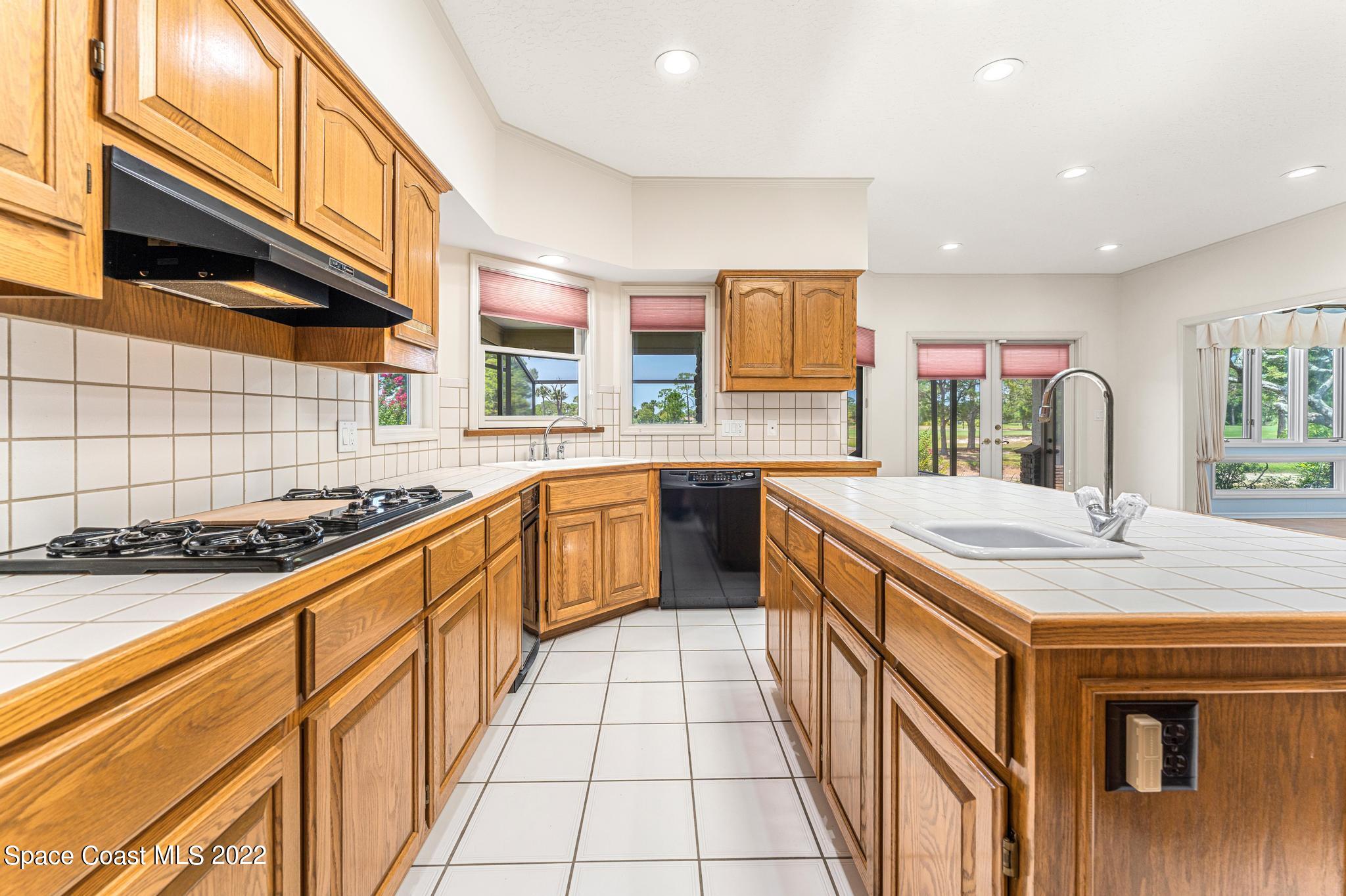750 Kerry Downs Circle Melbourne, FL 32940 - Photo 10 of 34 a kitchen with stainless steel appliances granite countertop a sink and cabinets