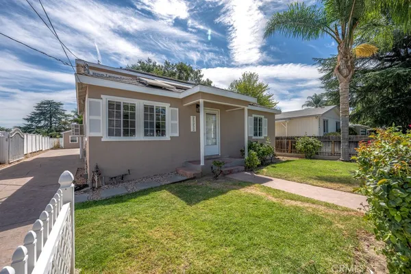 a view of a house with backyard and a tree