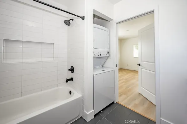 a view of an empty room with wooden floor and closet