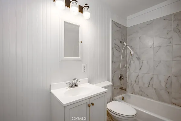 a bathroom with a toilet sink vanity tub and shower