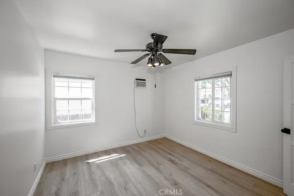 an empty room with a window and a fan