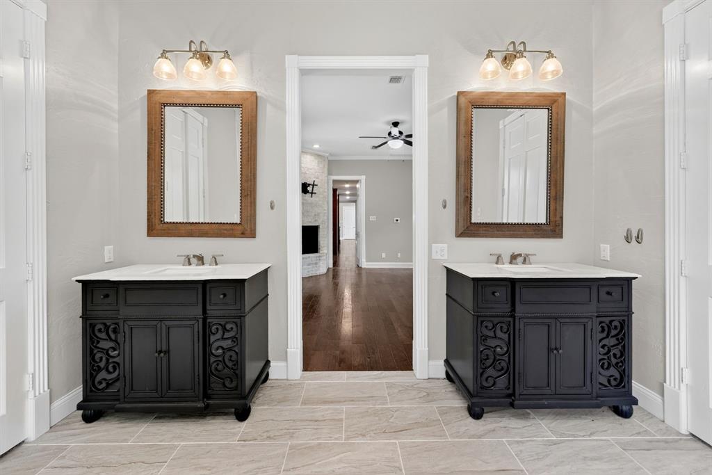 1201 Robbins Road Athens, TX 75751 - Photo 24 of 40 1st Floor-Dual black vanities with views of the primary bedroom & brick woodburning fireplace.