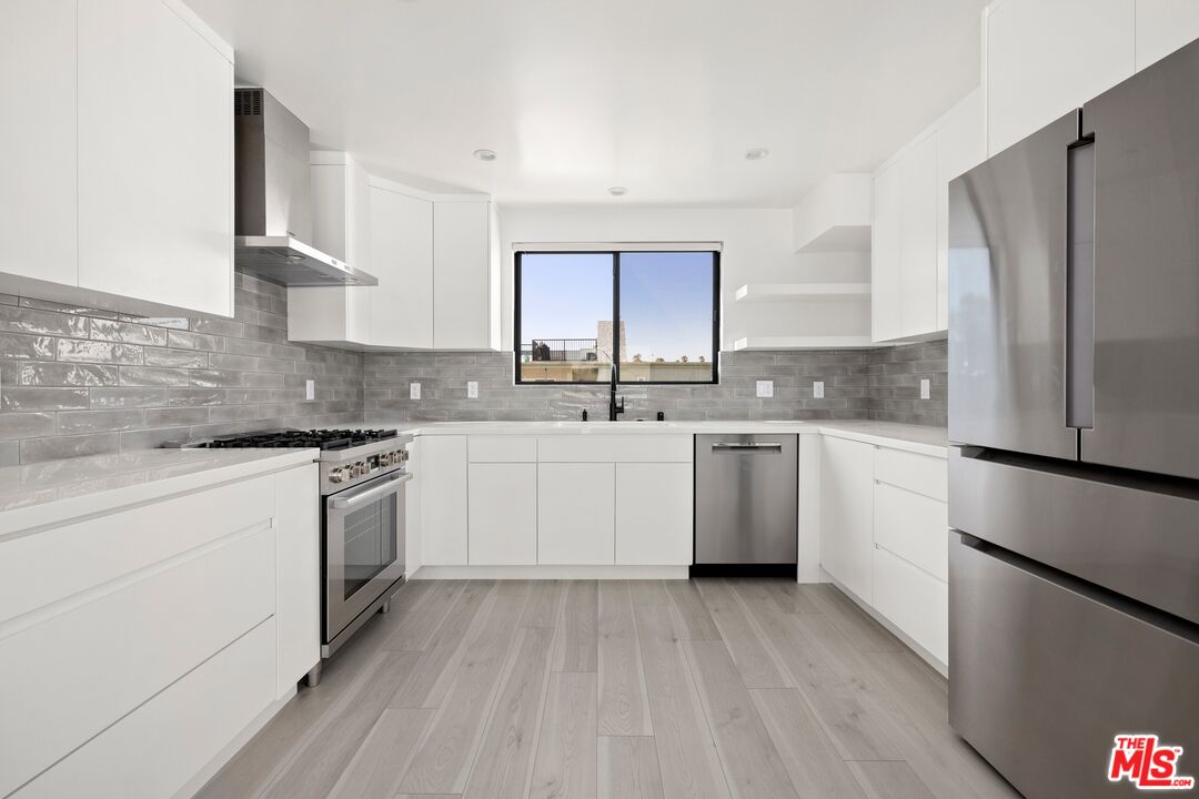 2225 4th Street, Unit B Santa Monica, CA 90405 - Photo 5 of 11 a kitchen with a sink cabinets stainless steel appliances and a window