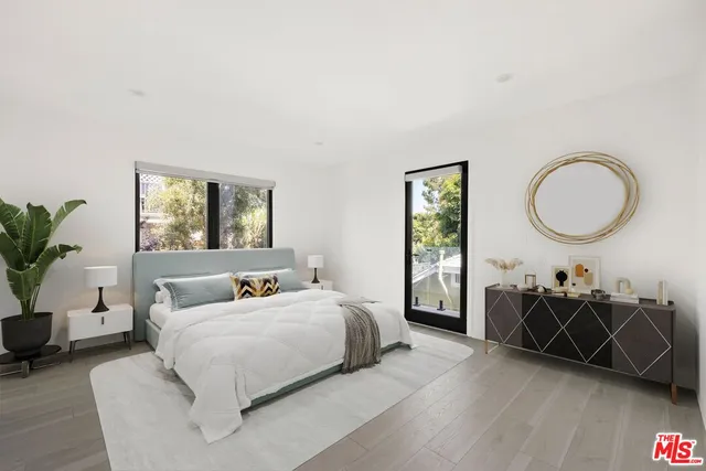 a bedroom with a bed a dresser and window