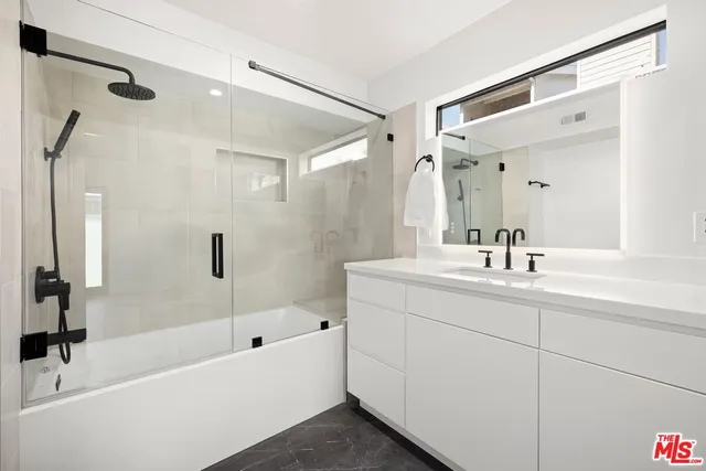a bathroom with a tub sink and mirror