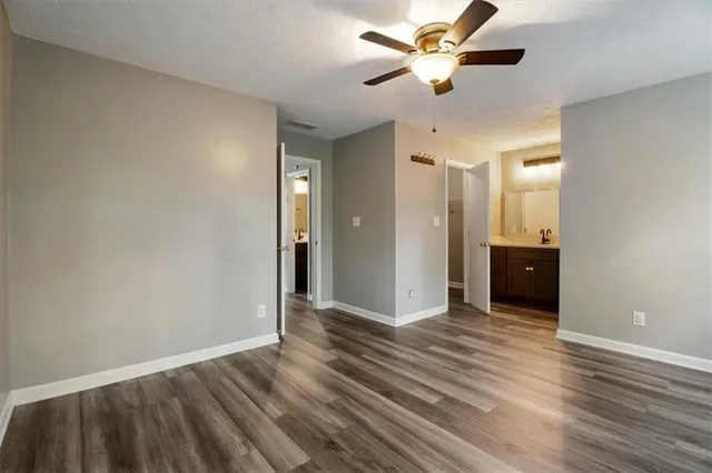 wooden floor in an empty room with a fan