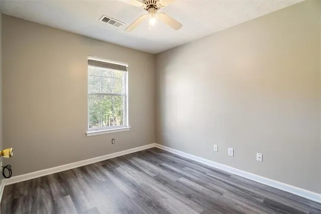 an empty room with a window and a ceiling fan
