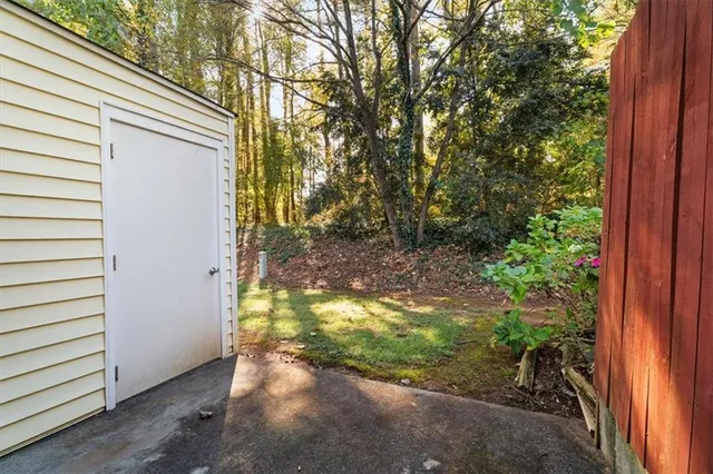 a view of a yard with potted plants and large tree