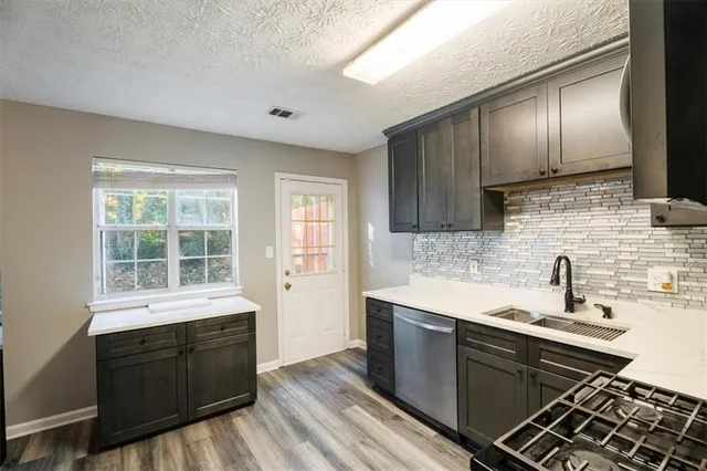 a kitchen with a sink stove and wooden cabinets