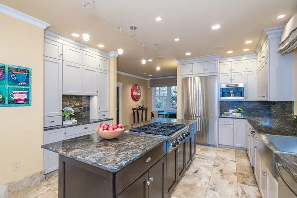 a kitchen with stainless steel appliances granite countertop a sink stove and refrigerator
