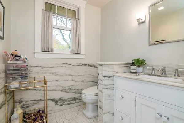 a bathroom with a granite countertop sink mirror and a toilet
