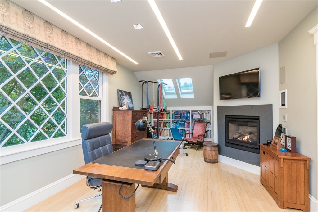 9 Harkness Road Pelham, MA 01002 - Photo 24 of 42 a living room with furniture a fireplace and a flat screen tv
