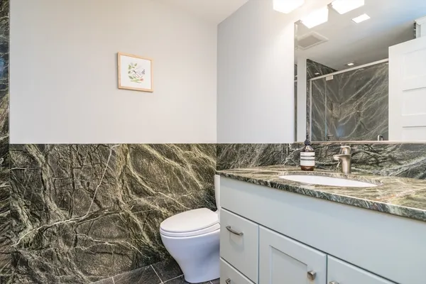 a bathroom with a toilet sink and mirror