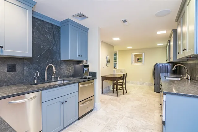 a kitchen with stainless steel appliances granite countertop a sink and a stove top oven with wooden floor