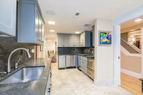 a kitchen with stainless steel appliances granite countertop a sink and a stove top oven with wooden floor