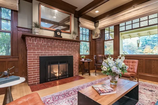 a living room with furniture a fireplace and a floor to ceiling window