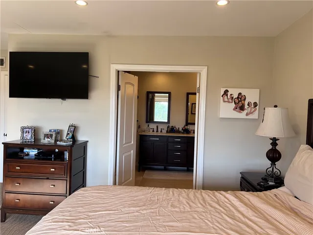 a bedroom with a bed and a flat screen tv