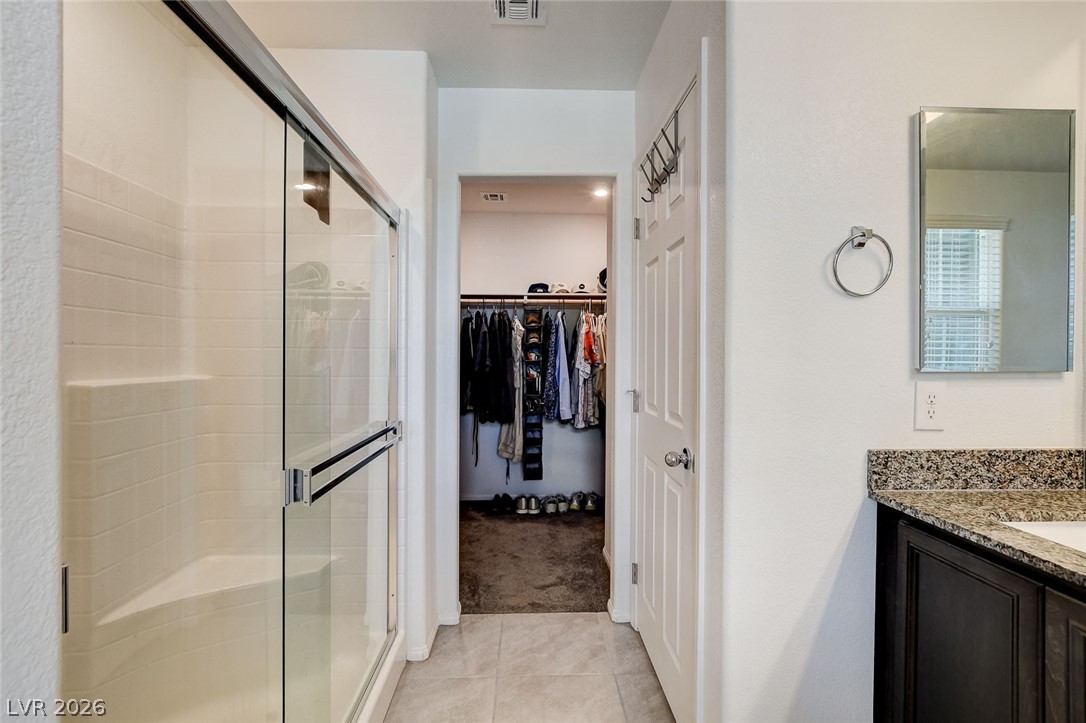 484 Filaree Place Henderson, NV 89015 - Photo 50 of 71 This bathroom features a shower with a glass door and a well-organized walk-in closet.