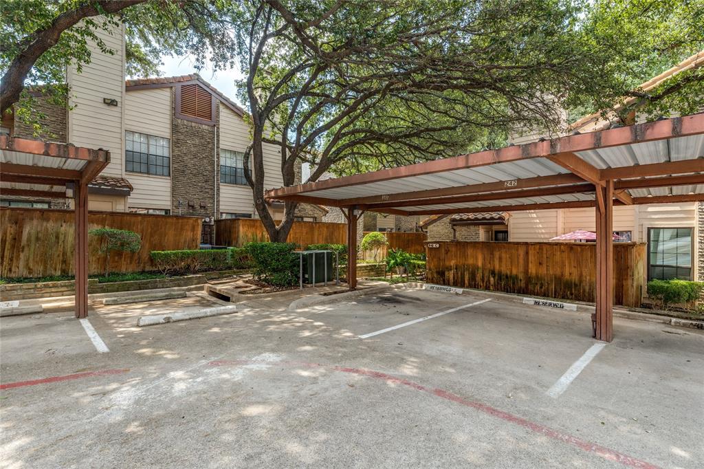5626 Preston Oaks Road, Unit 42B Dallas, TX 75254 - Photo 4 of 25 a view of a patio with table and chairs under an umbrella with large trees
