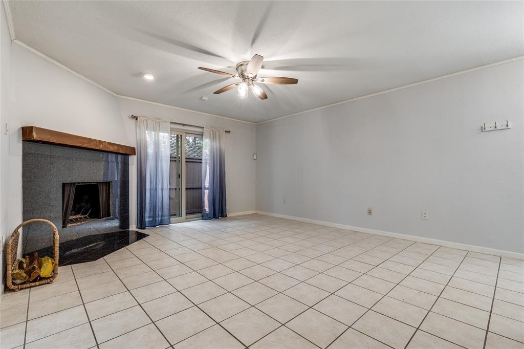 5626 Preston Oaks Road, Unit 42B Dallas, TX 75254 - Photo 7 of 25 a view of an empty room with a fireplace and a chandelier fan