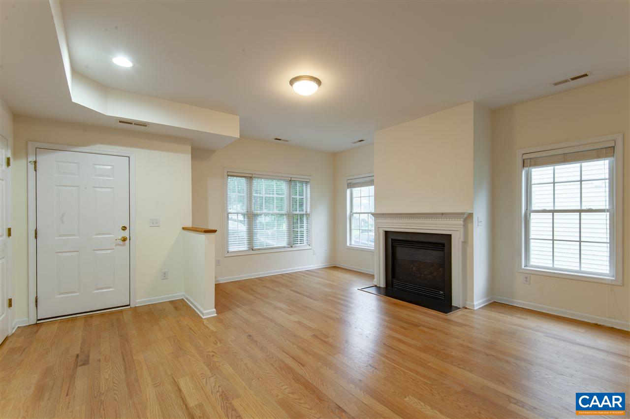 907 Raymond Road Charlottesville, VA 22902 - Photo 2 of 34 an empty room with wooden floor fireplace and windows