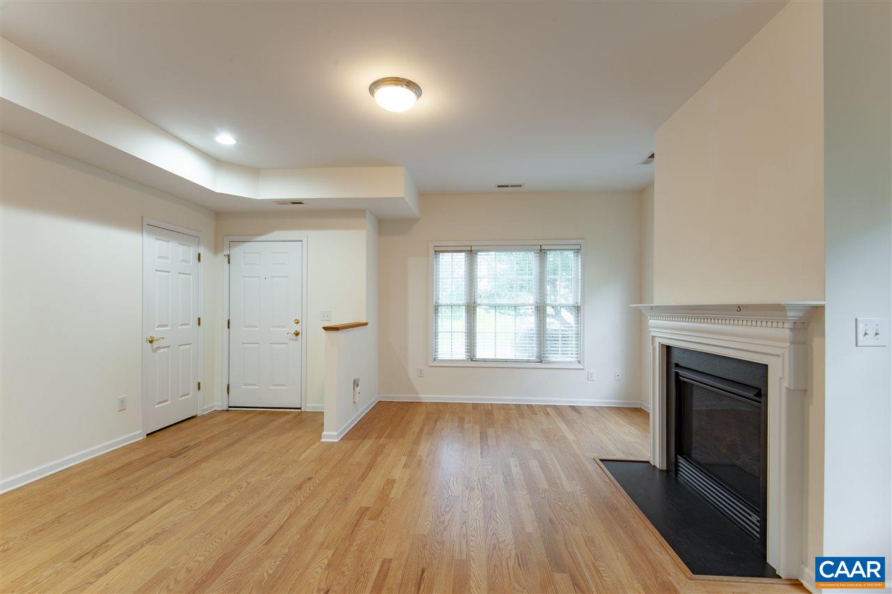 907 Raymond Road Charlottesville, VA 22902 - Photo 3 of 34 an empty room with wooden floor and fireplace