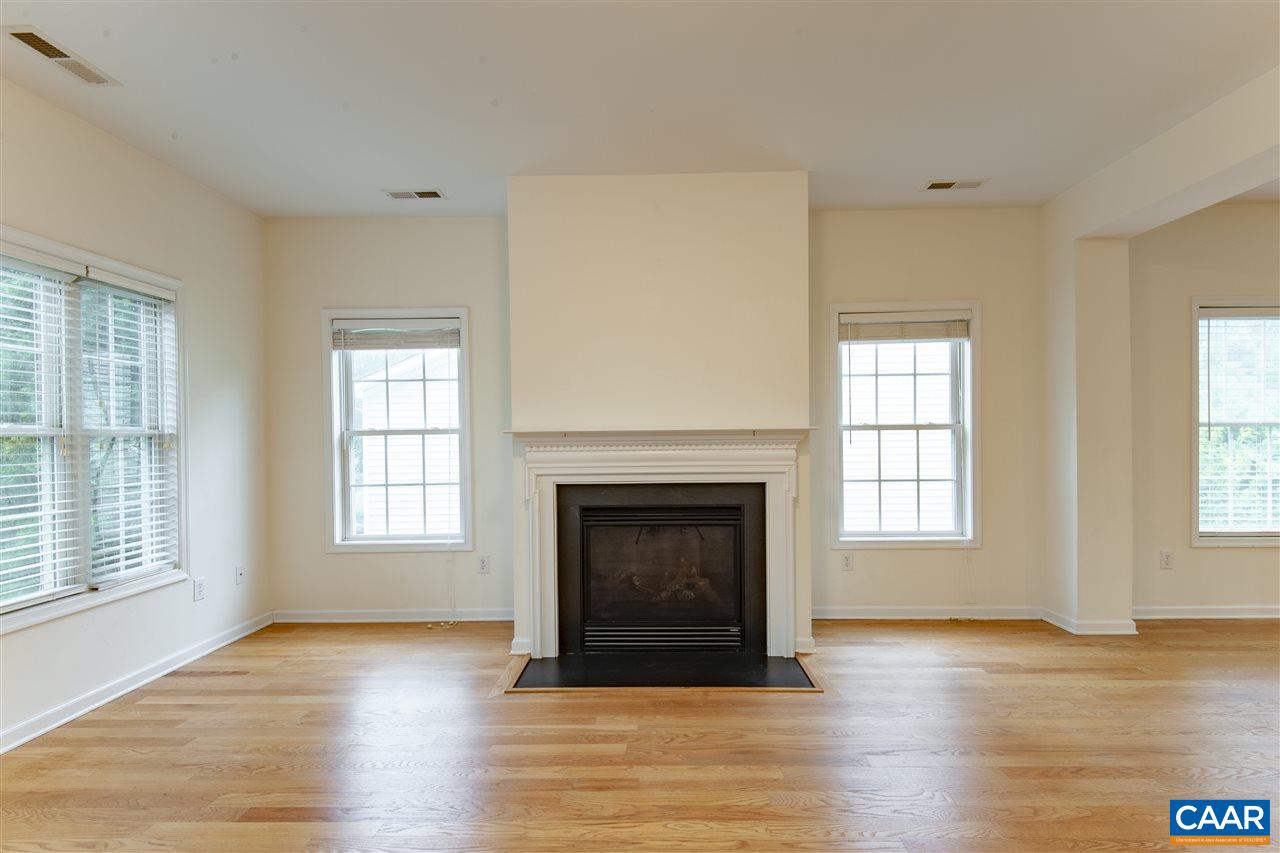 907 Raymond Road Charlottesville, VA 22902 - Photo 4 of 34 an empty room with wooden floor fireplace and windows
