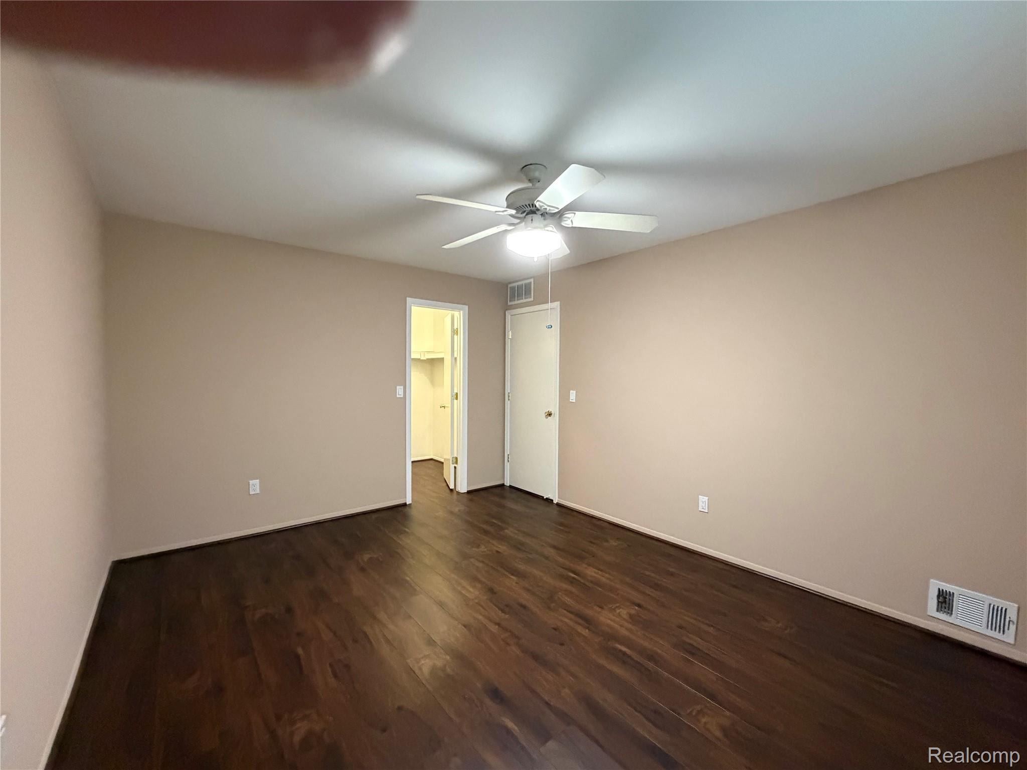 5220 West Utica Road Utica, MI 48317 - Photo 21 of 24 Spacious room featuring dark wood-finish flooring, a ceiling fan with integrated lighting, and neutral wall tones