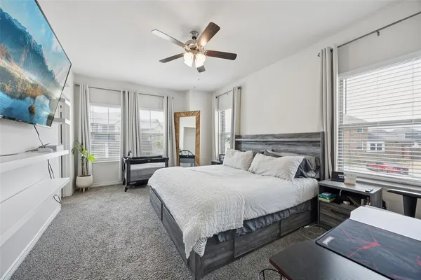 a spacious bedroom with a bed and a large window