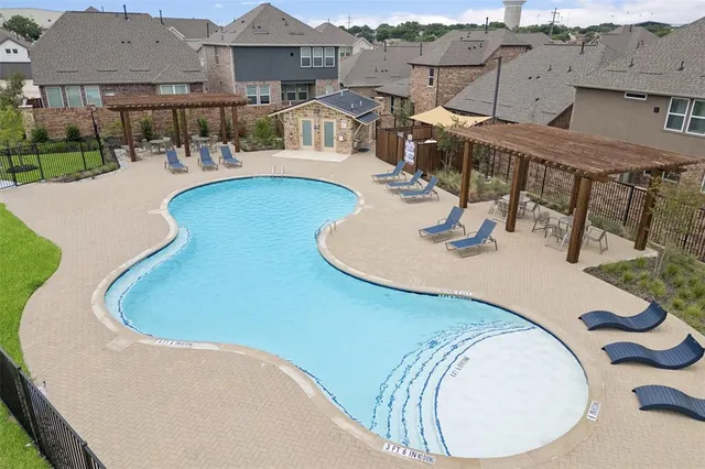 an aerial view of a house with swimming pool and patio