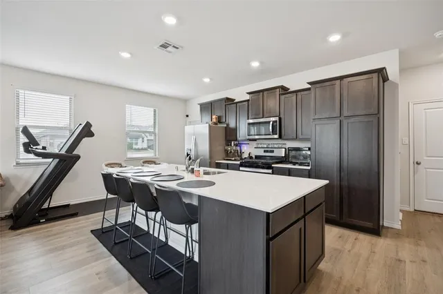 a kitchen with a sink a counter space and stainless steel appliances