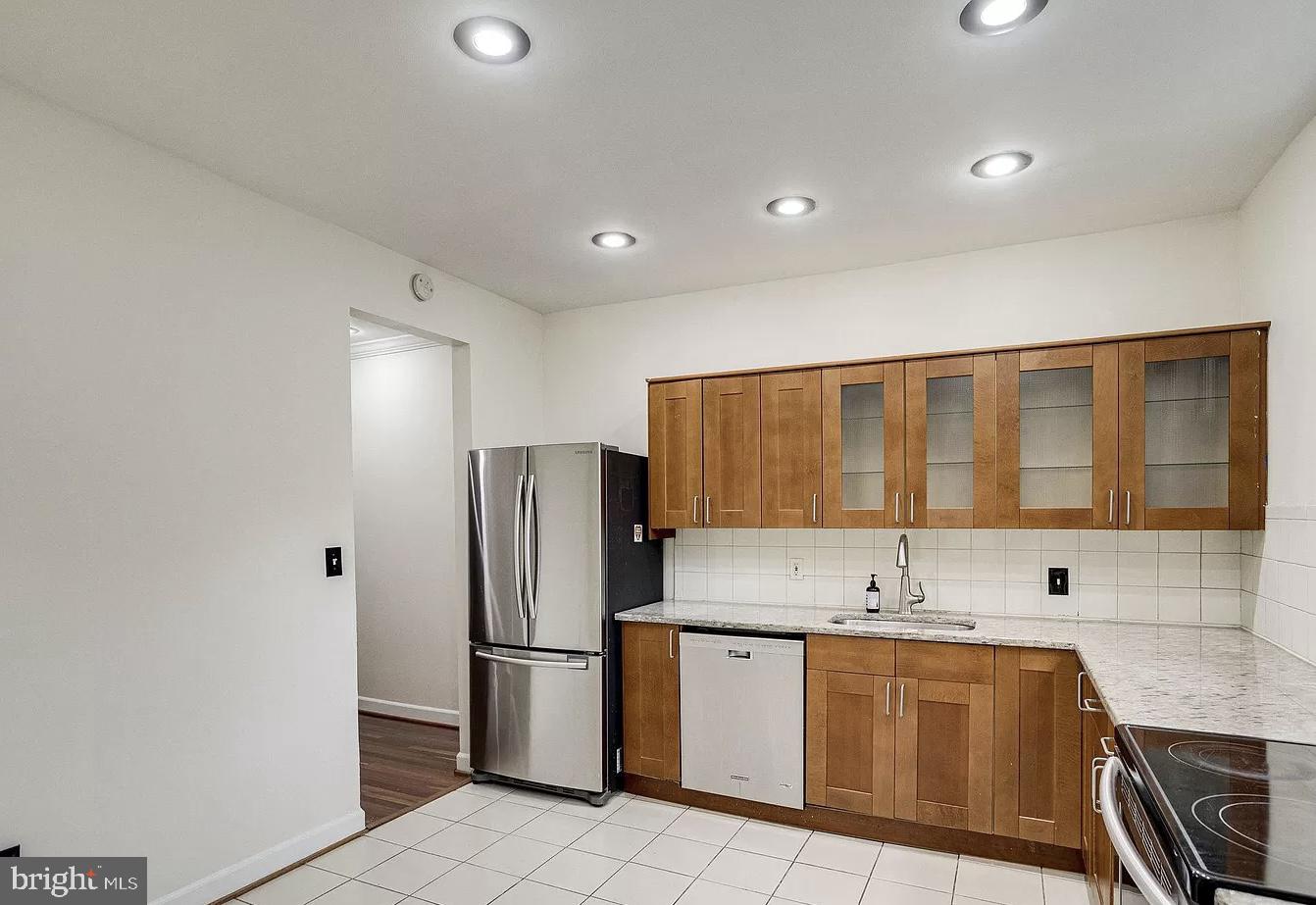 595 Columbia Road Northwest Washington, DC 20001 - Photo 12 of 36 a kitchen with stainless steel appliances granite countertop a refrigerator and a sink