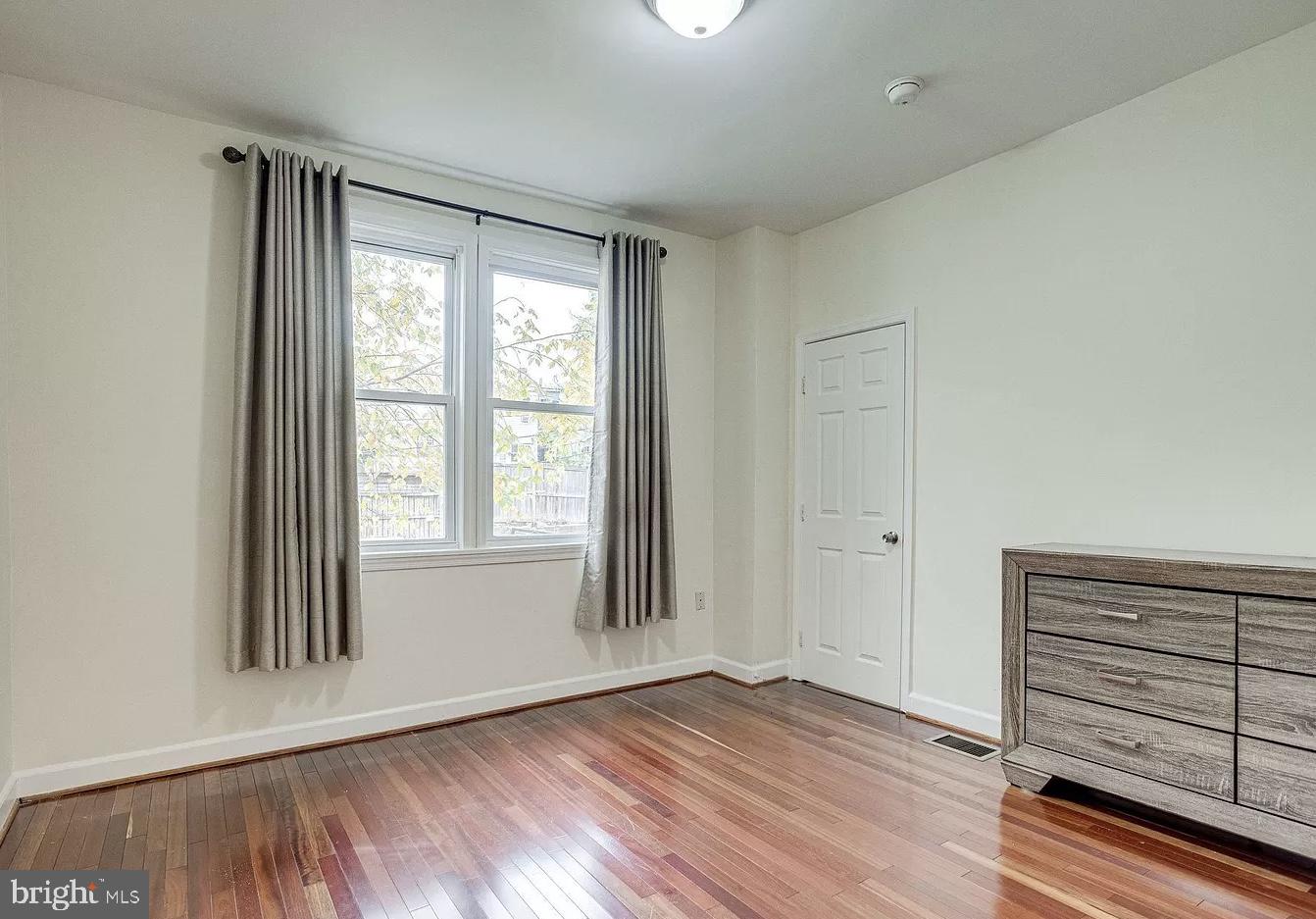 595 Columbia Road Northwest Washington, DC 20001 - Photo 15 of 36 an empty room with wooden floor and windows